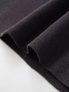 Detailed macro view of dark purple knitted fabric texture and soft ribbed weave structure