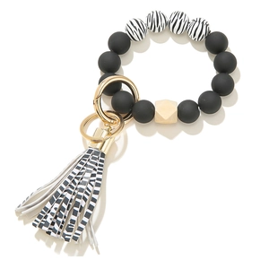 Detailed macro of silicone bead keychain with zebra tassel and gold metal ring