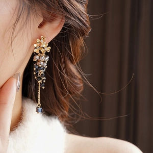 Detail of silver needle tassel earrings with crystals on a model for luxury look