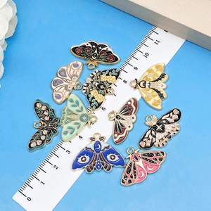 Colorful enamel butterfly pendants for DIY jewelry making shown with a measurement scale