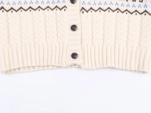 Détail de l'ourlet du cardigan en tricot beige avec bords côtelés et motif classique