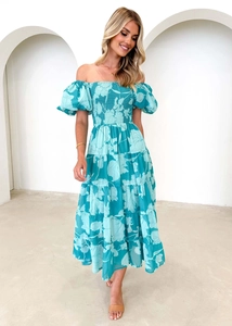 Détail d'une robe mi-longue fleurie bleue à épaules dénudées et manches bouffantes