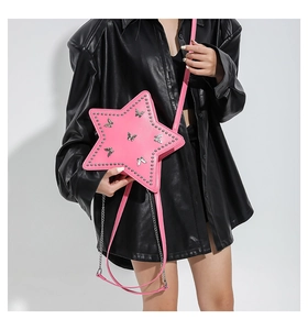 Detail of pink star-shaped crossbody bag with silver rivets and butterfly charms