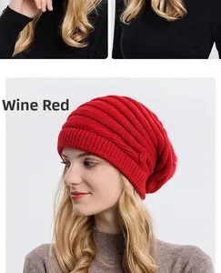 Détail du bonnet en maille bordeaux montrant la texture épaisse et le bouton décoratif