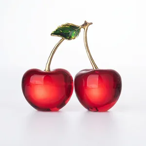 Macro view of crystal cherry ornament with red translucent fruit and golden metal stems