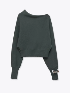 Detail of forest green cropped knit top with asymmetric neckline and metal sleeve buckle