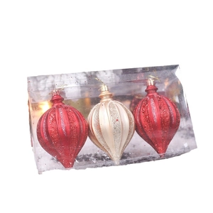 Three onion-shaped glitter Christmas ornaments in red and gold in a clear display box