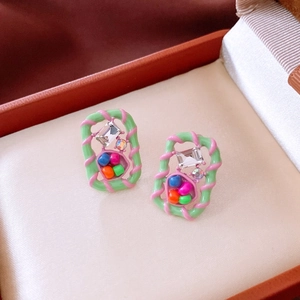 Detail of vintage square earrings with colorful beads and zircon in a jewelry box