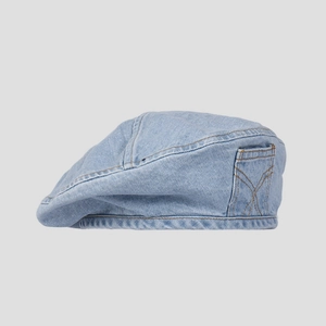 Detail view of denim beret featuring a side decorative pocket and contrast yellow stitching