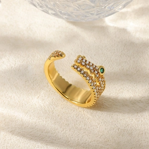 Detail of crocodile ring with white cubic zirconia and green gem eyes in gold finish