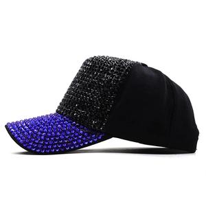 Side view of black baseball cap with blue and black rhinestones on brim and front