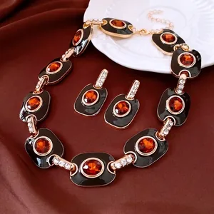 Parure bijoux vintage dorée en émail noir et ambre sur soie rouge luxueuse