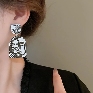 Close-up of model wearing abstract portrait line art earrings in monochrome finish