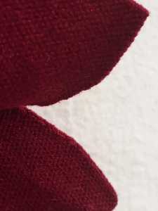 Vue macro d'un tissu en maille bordeaux montrant la texture épaisse du tricot