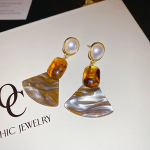 Detailed view of vintage amber resin earrings with marble texture fan-shaped pendants