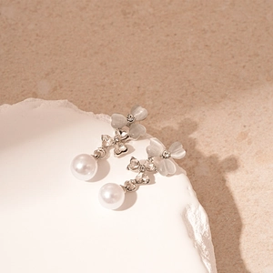 Détail de boucles d'oreilles fleur œil de chat avec perles sur plateau de pierre
