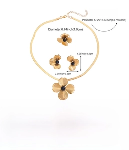 Detail view of golden flower jewelry set featuring hollow petals and black core accents