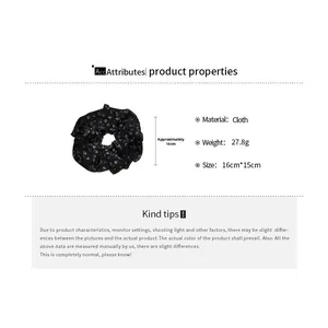 Detail view of a black floral fabric scrunchie with size measurements and cloth texture