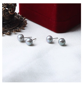 Detailed view of grey freshwater pearl earrings with S925 silver studs on velvet