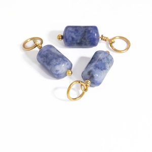 Three DIY natural blue stone cylinder pendants wrapped in gold wire with jump rings