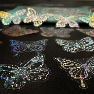 Macro shot of holographic PET butterfly stickers with rainbow laser light effects