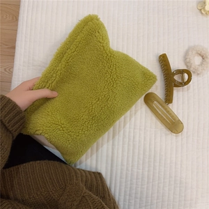 Detail of soft green faux shearling pouch texture with stylish hair accessories