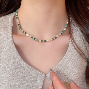 Detailansicht der Perlenkette mit Natursteinen getragen von einem eleganten Model