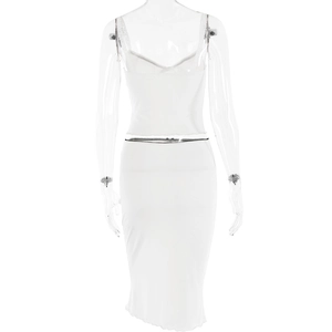Detailed view of the white two-piece set featuring a crop top and skirt with ruffled edges