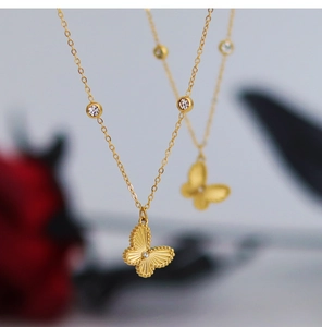 Macro shot of gold butterfly necklace pendant with radiant texture and white zircon