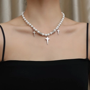 Detail of pearl necklace with silver star pendants and micro-set spacers on a neck