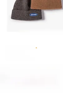 Detail of ORDERLINESS logo patch on ribbed knit winter beanies in various colors