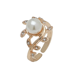 Elegant gold pearl ring with leaf design and small crystals on a white background