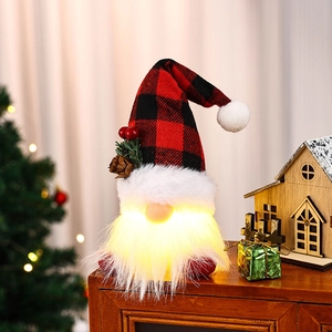 Close-up of a glowing Christmas gnome with a red plaid hat and warm LED lighting effect
