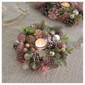 Detailed pink pinecone candle holder ornament with glass cup on a lace tablecloth