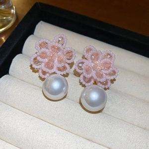Macro shot of pink floral bead cluster earrings with a large round white pearl drop