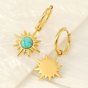 Detailed macro view of gold sunburst hoop earrings with a turquoise center stone inlay