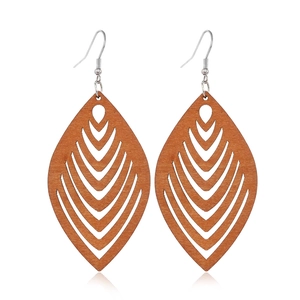 Detailed close-up of brown leaf-shaped hollowed wood earrings with silver hooks