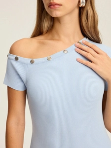 Détail d'une robe en maille bleu clair avec boutons en métal S sur l'encolure biaise