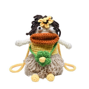Handmade crochet cross-body bag featuring a quirky face with orange lips and a clover charm
