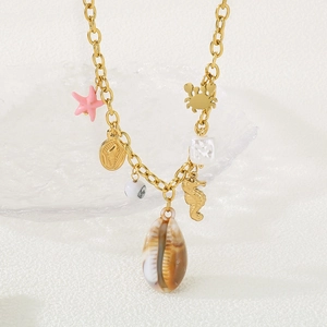 Détail de collier doré style plage avec pendentifs hippocampe, crabe et étoile de mer