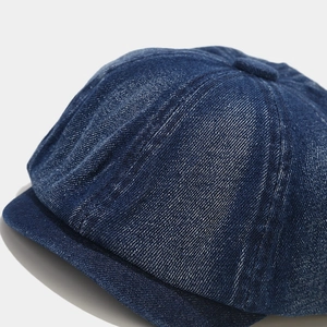 Classic dark blue denim newsboy cap with octagonal panels and premium stitching texture
