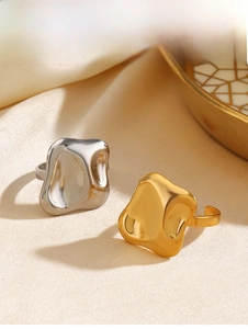 Detailed view of fluid liquid metal style rings in gold and silver on soft silk fabric