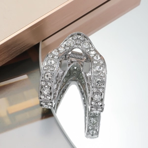 V-shaped silver hair claw clip with rhinestones for high ponytail on reflective surface