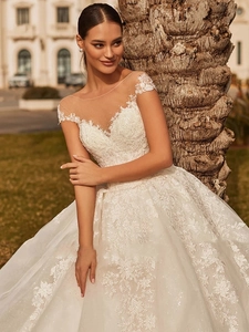 Détail de la robe de mariée blanche avec dentelle florale et décolleté illusion transparent