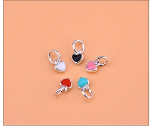 Detailed close-up of heart-shaped enamel pendants in five colors for DIY jewelry making