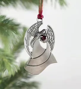 Close-up of vintage silver angel Christmas ornament with a red heart gem and silk ribbon