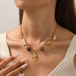 Gold-plated western necklace with heart, boot, hat and moon pendants on a model