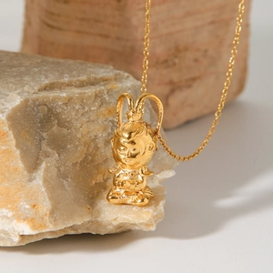Gold Sun Wukong pendant necklace on natural stone display with a clean white background