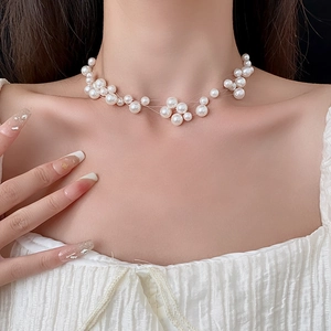 Close-up of elegant multilayered pearl necklace worn on model's neck and collarbone