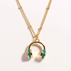 Detail of golden ball chain necklace with turquoise enamel headphone pendant design